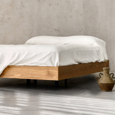 Floating bed frame in American Oak with striped linen bedding for a girls bedroom