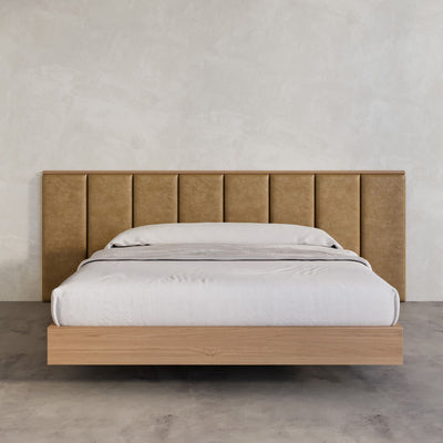 Leather bed frame with timber floating bed base in a large micro cement walled bedroom