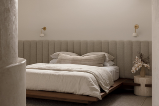Master bedroom featuring timber platform bed with panelled bed head and built in travertine plinths.