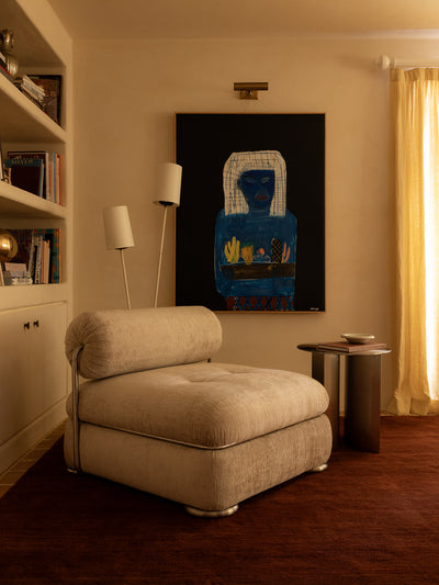 Living room with beige lido occasional chair, side table, and abstract painting on the wall.