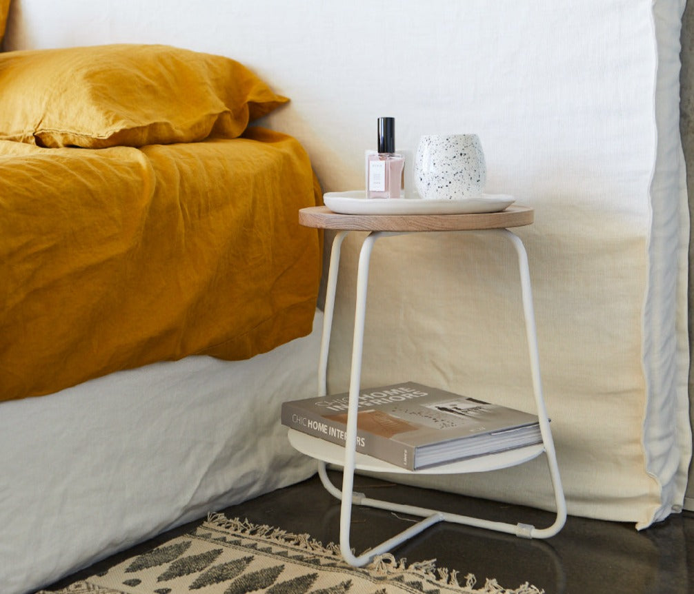 Wide bed head in white linen, pictured in a master bedroom against concrete walls