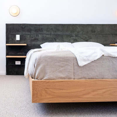 Floating bed base in American Oak, with a green velvet bed head in a master bedroom