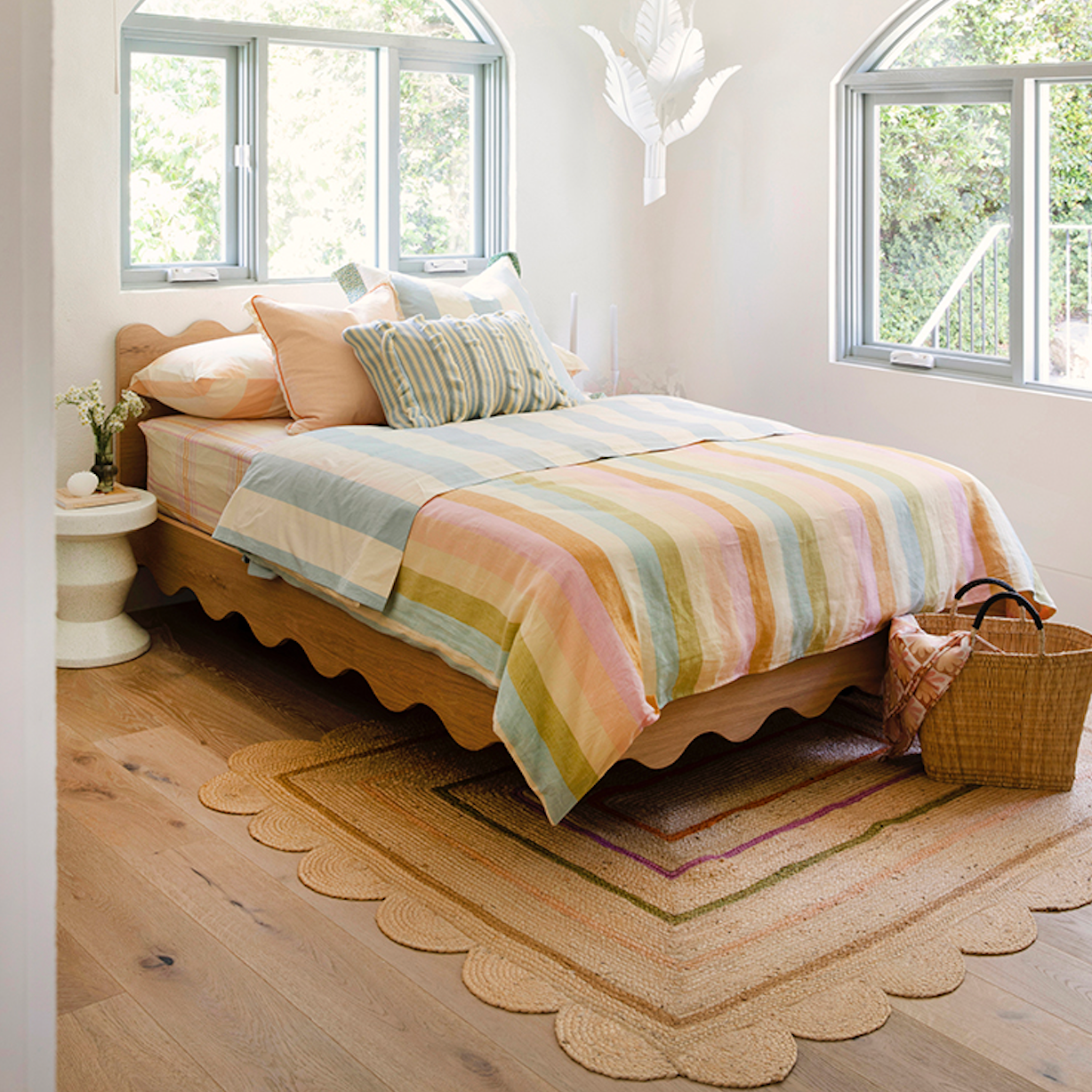 Floating girls bed frame pictured in a light filled girls bedroom dressed in striped linen sheets