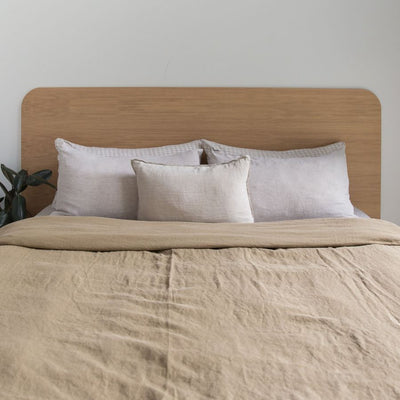 Floating Bed Frame in American Oak, pictured with olive green linen in a guest bedroom. Made in QLD by Create Estate