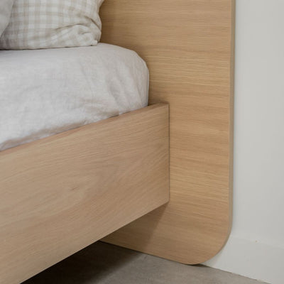 Floating Bed Frame in American Oak, pictured with olive green linen in a guest bedroom. Made in QLD by Create Estate