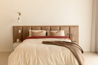 Leather look panelled bed head in master bedroom with timber feature strip and sheers drapes to the side