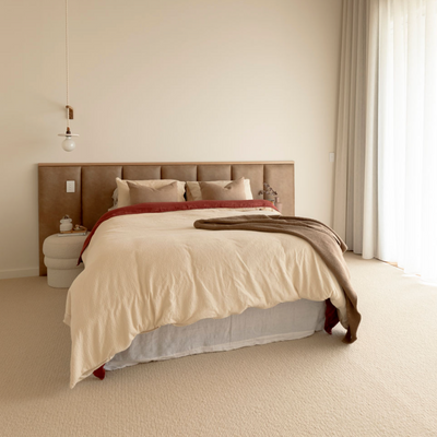 Leather look panelled bed head in master bedroom with timber feature strip and sheers drapes to the side