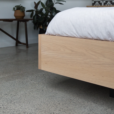 Floating Bed Frame in American Oak, pictured with olive green linen in a guest bedroom. Made in QLD by Create Estate