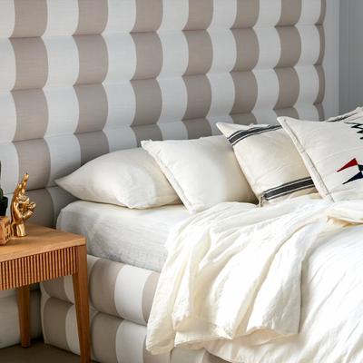 Fabric bed base, upholstered in white and natural stripe fabric for a teenage boys bedroom